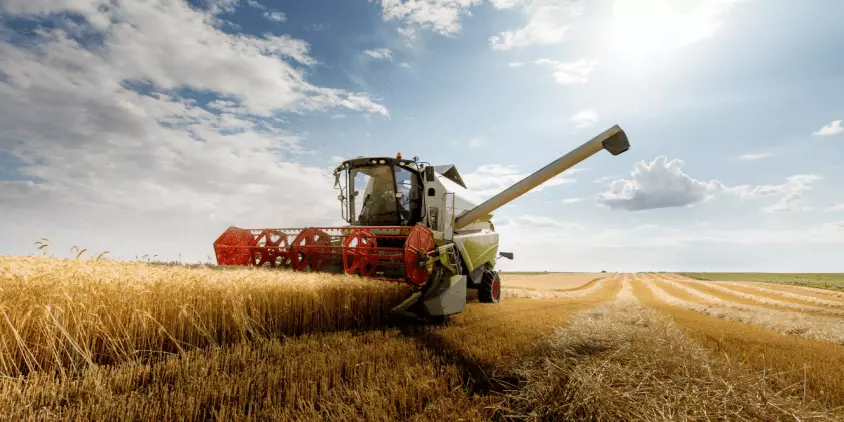 Tractor and modern agricultural equipment in a field.